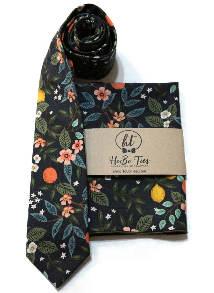 Navy Citrus Grove Floral Necktie displayed with a matching pocket square, a perfect addition to handcrafted neckties and wedding accessories for men.