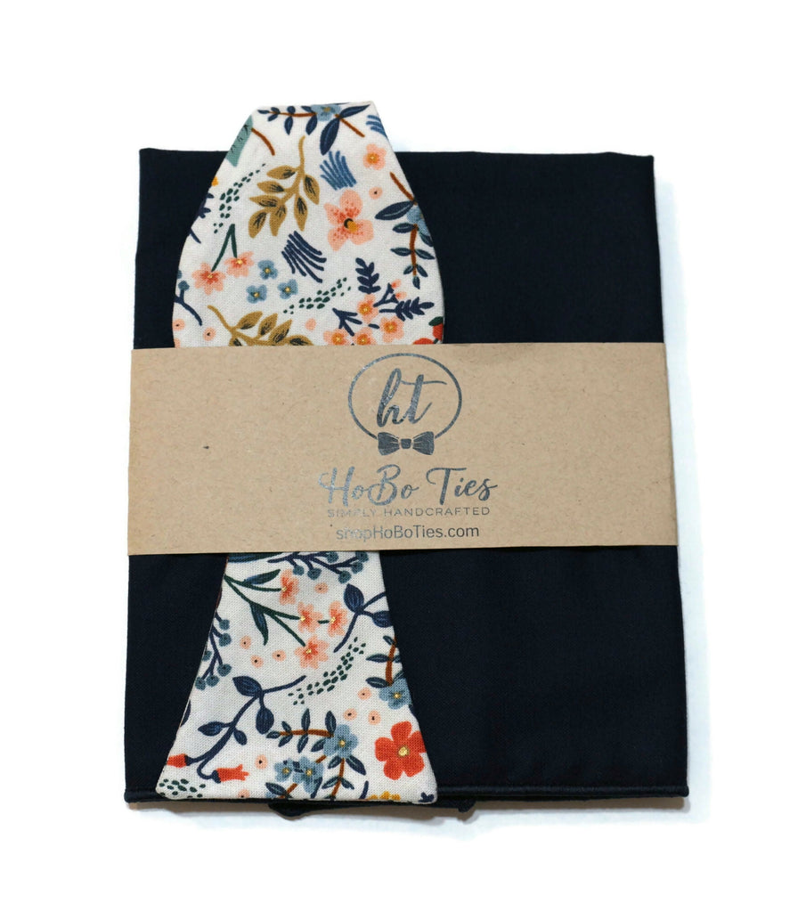 White Metallic Wildwood Floral Bow Tie wrapped in kraft paper with floral design, showcasing handcrafted neckties and handmade bow ties.