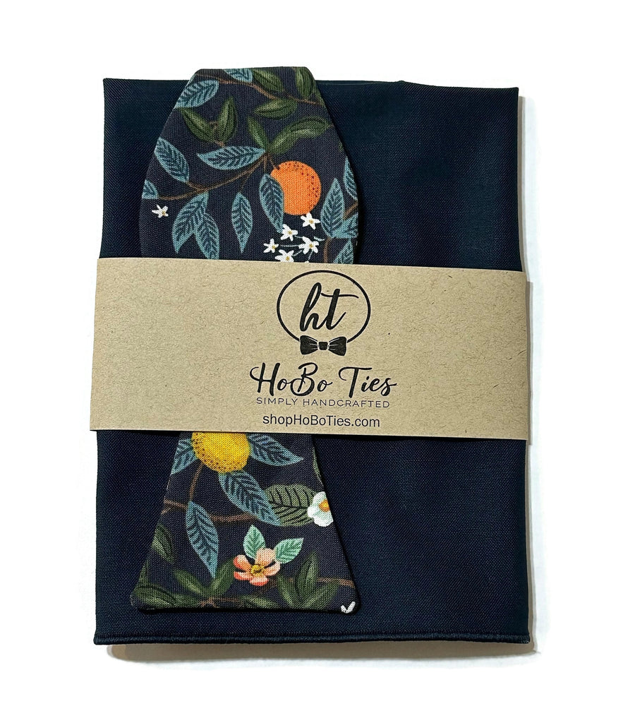 Navy Citrus Grove Floral Bow Tie displayed with a matching pocket square, handcrafted neckties for men and boys.