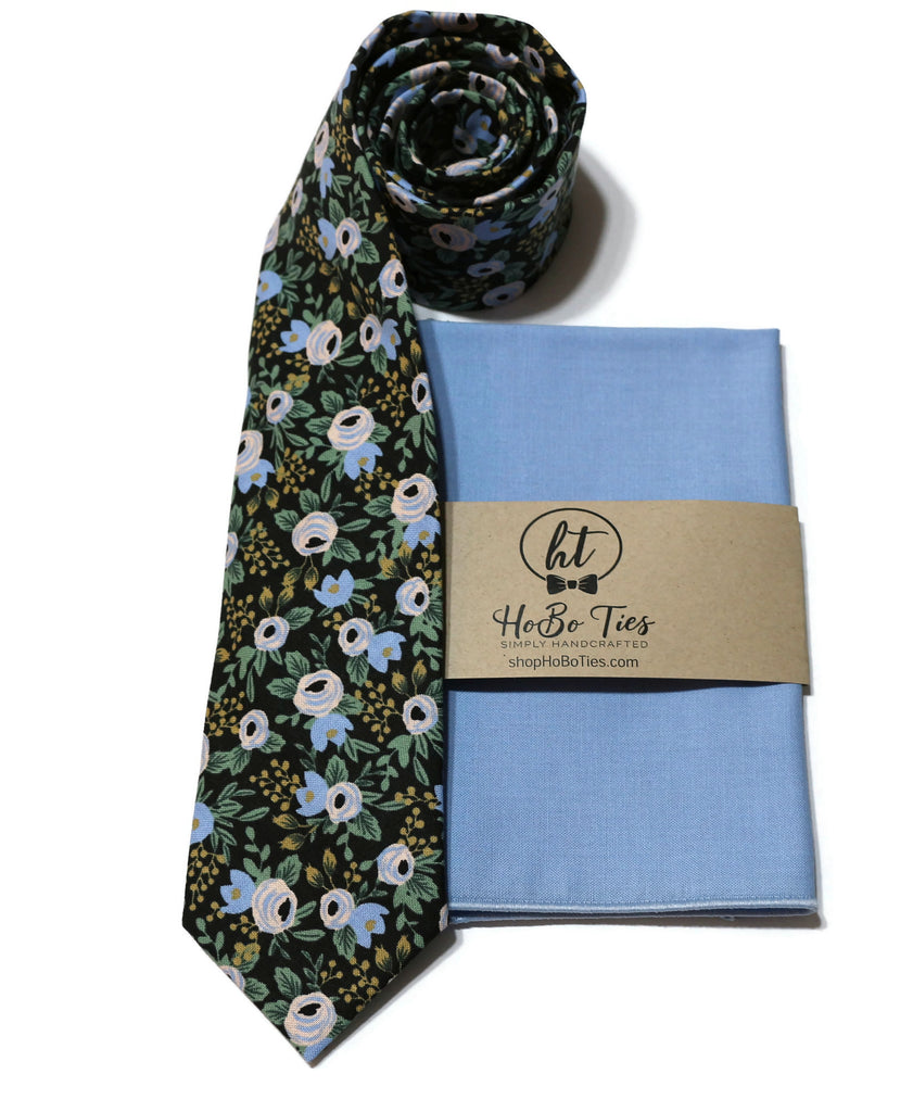 Black Rosa Floral Necktie featuring a floral pattern, accompanied by a light blue pocket square for men's formal wear.