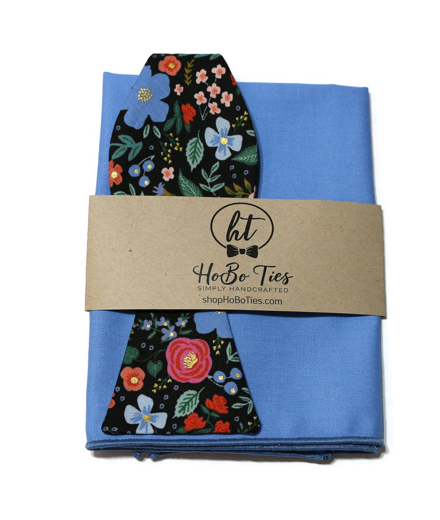 Black Wild Rose Floral Bow Tie paired with a blue pocket square, showcasing handcrafted neckties and unique floral patterns.