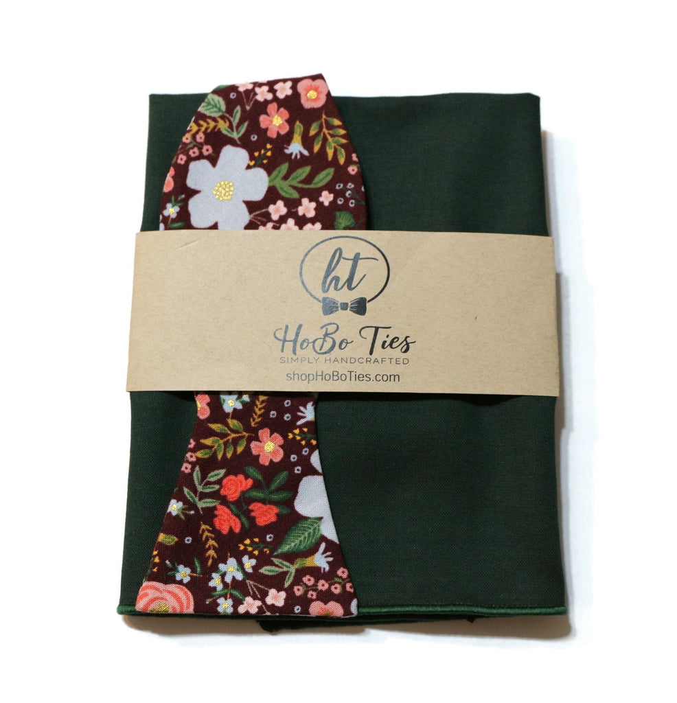 Burgundy Wild Rose Floral Bow Tie with green fabric backdrop, showcasing handcrafted neckties and unique floral patterns.