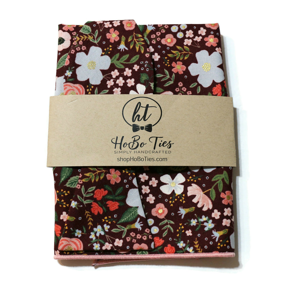 Burgundy Wild Rose Floral Bow Tie wrapped with a handmade tag, showcasing floral patterns for men’s accessories.