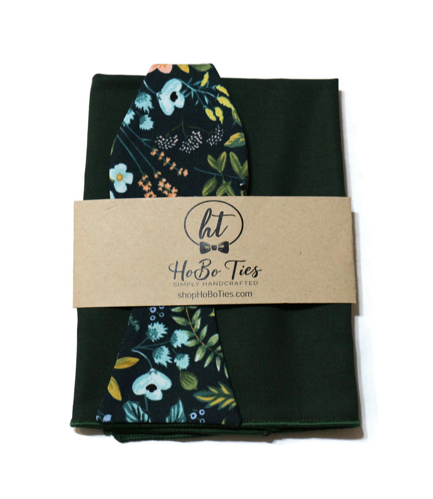 Navy Amalfi Floral Bow Tie with floral print on a green background, handcrafted neckties and men's accessories.